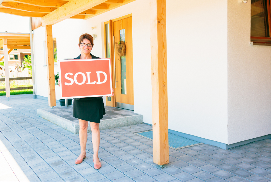 Agent Standing By Sold Home